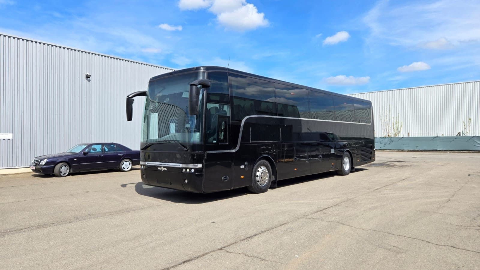 Black Van Hool BAS PREVOZ coach in front of a hall