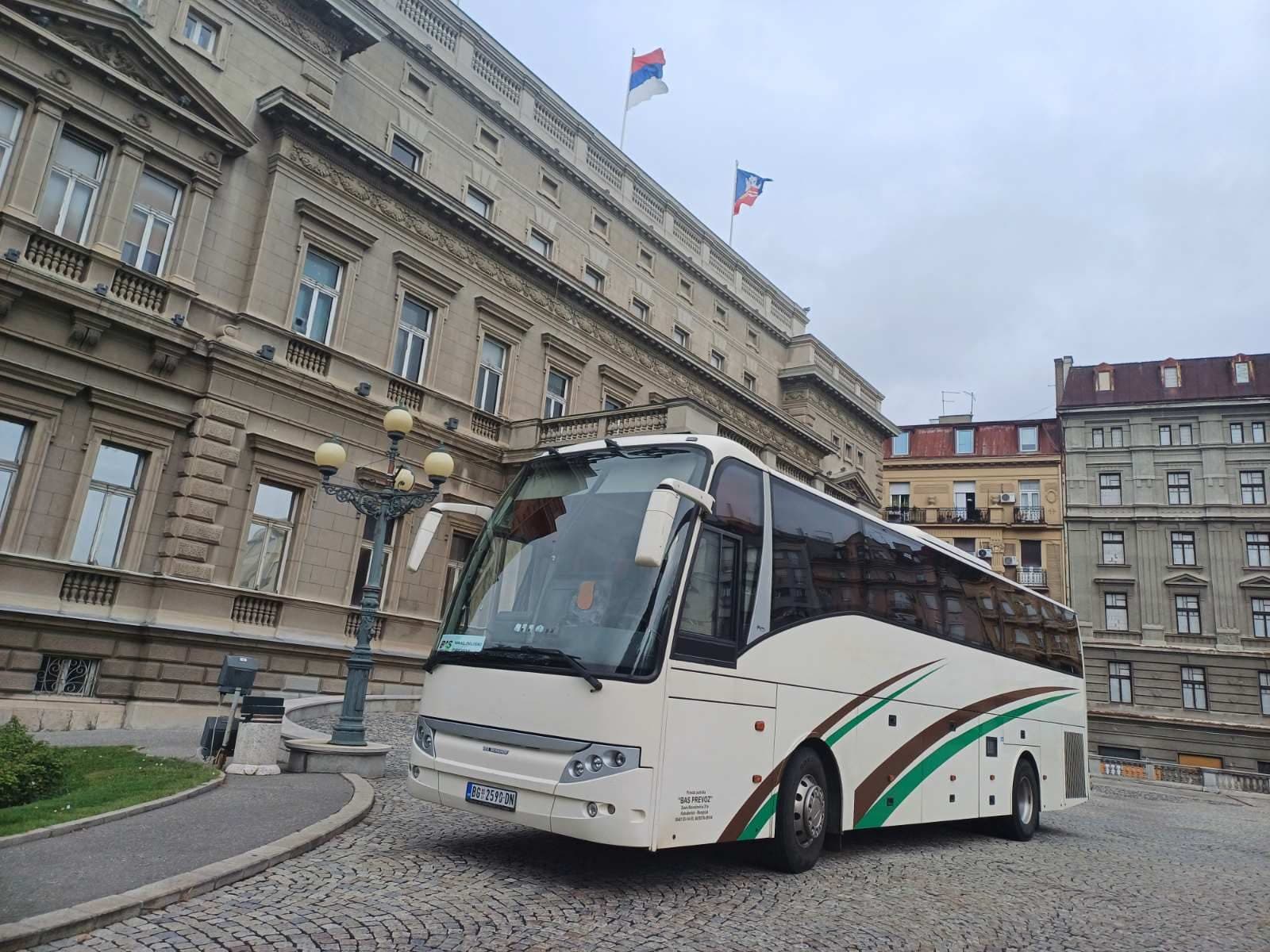 White BAS PREVOZ coach in front of a historic city building