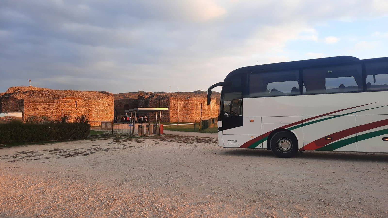 White coach beside a fortress wall