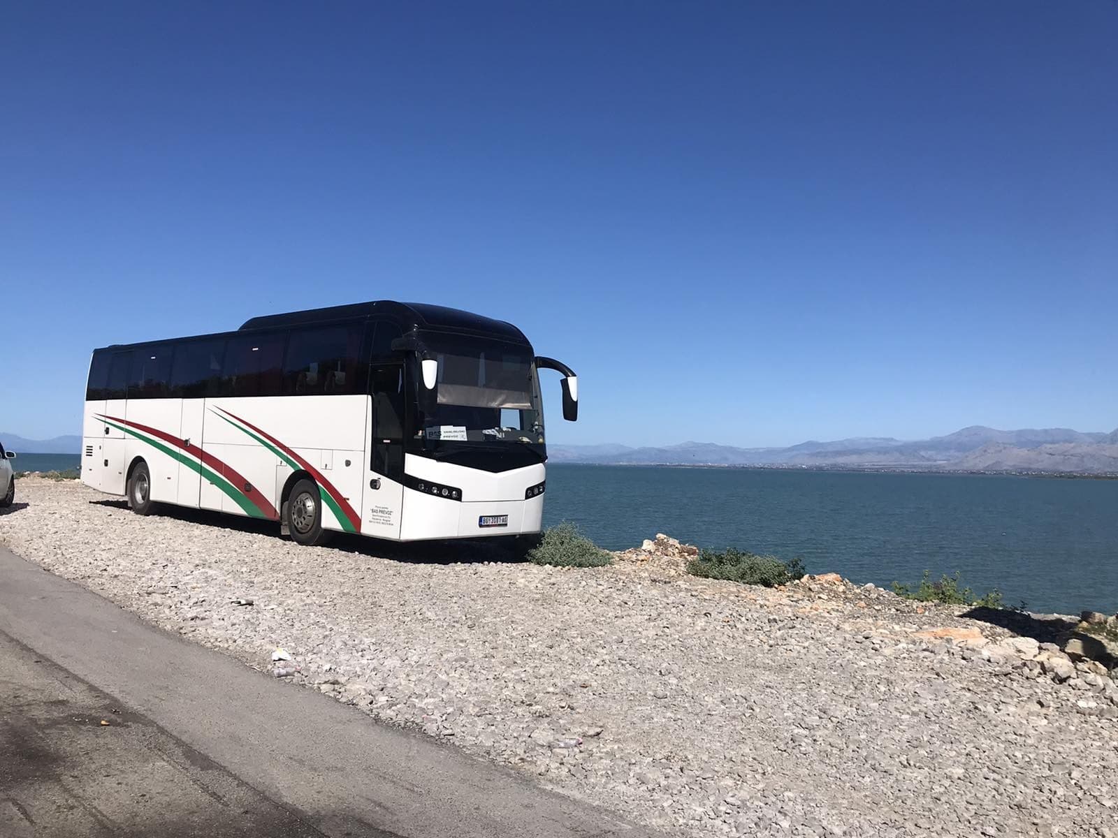 White coach on a lake shore