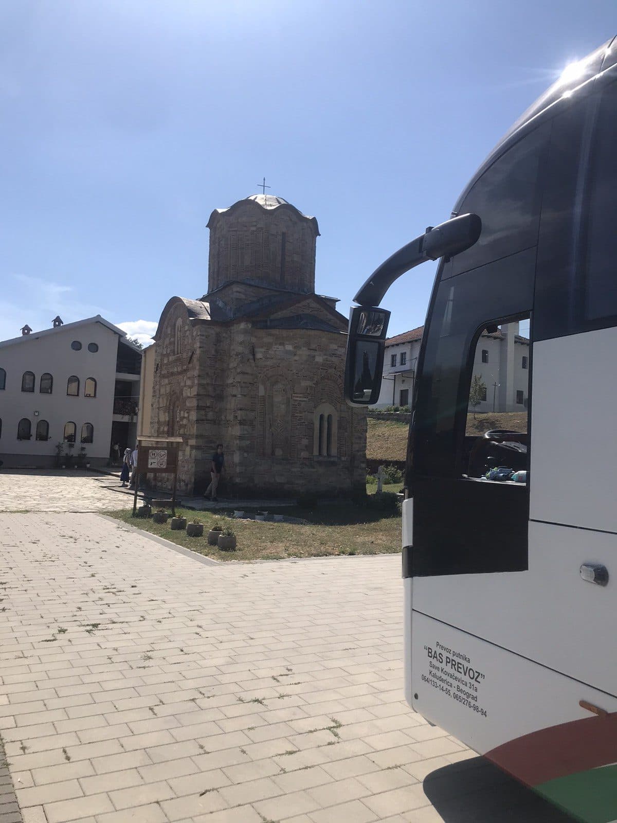 Coach beside a stone church