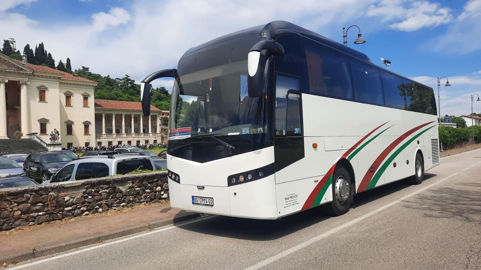 White coach beside a historic building
