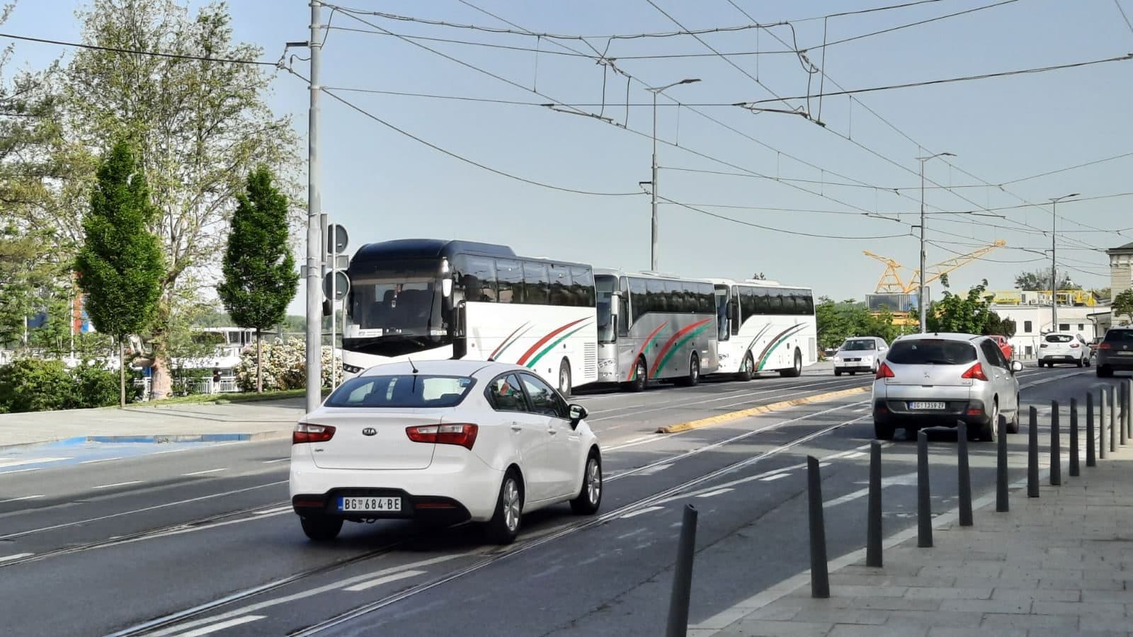 Coach on a city street with trams