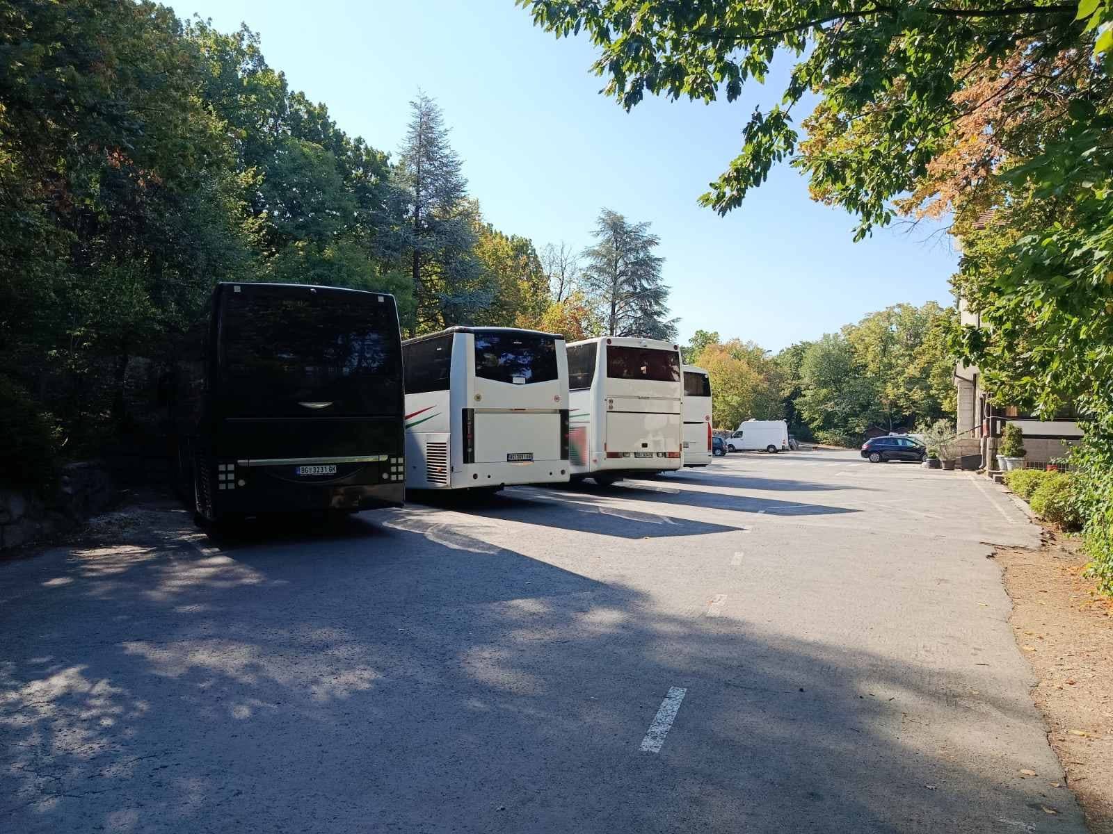 Black and white BAS PREVOZ coaches parked in a park