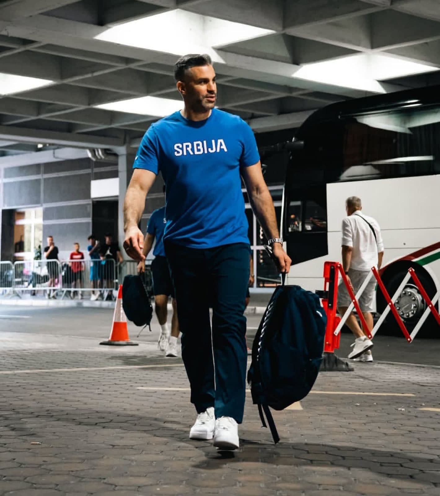 Serbian national team staff member in a blue shirt in front of the coach