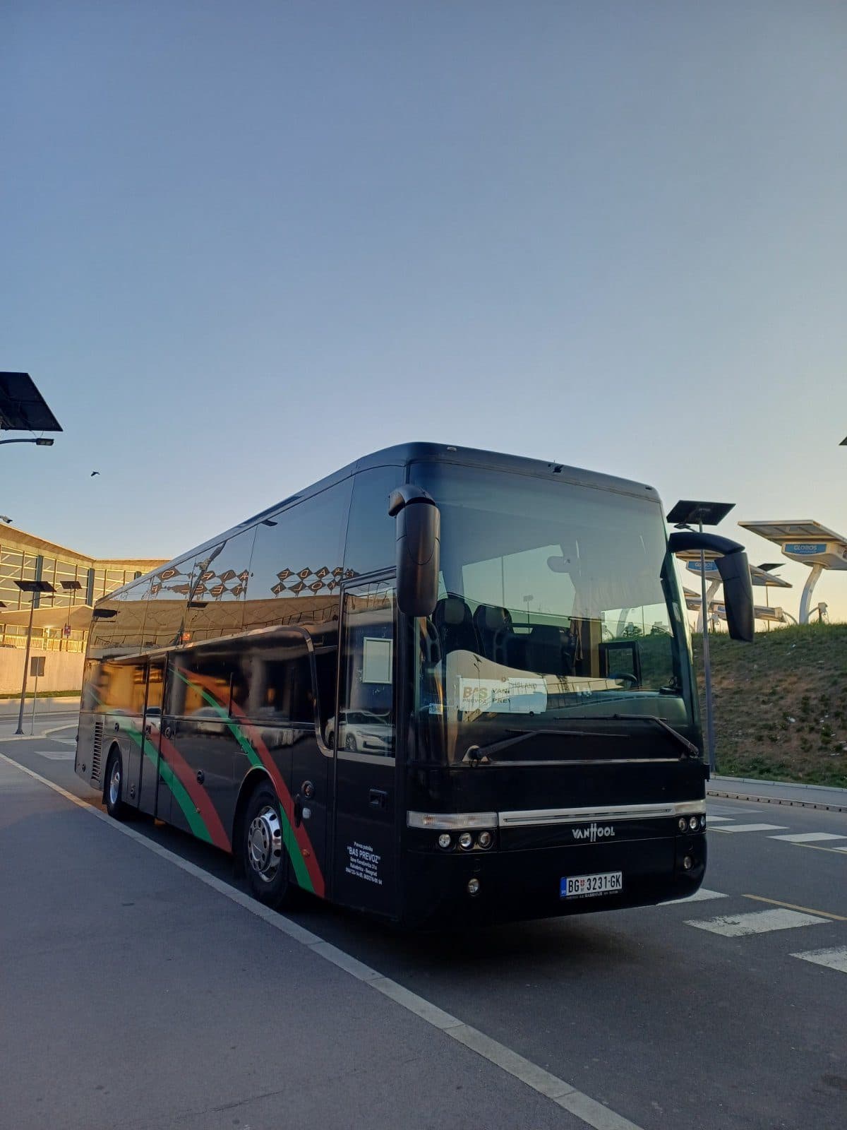 Black Van Hool coach outside the airport, front view