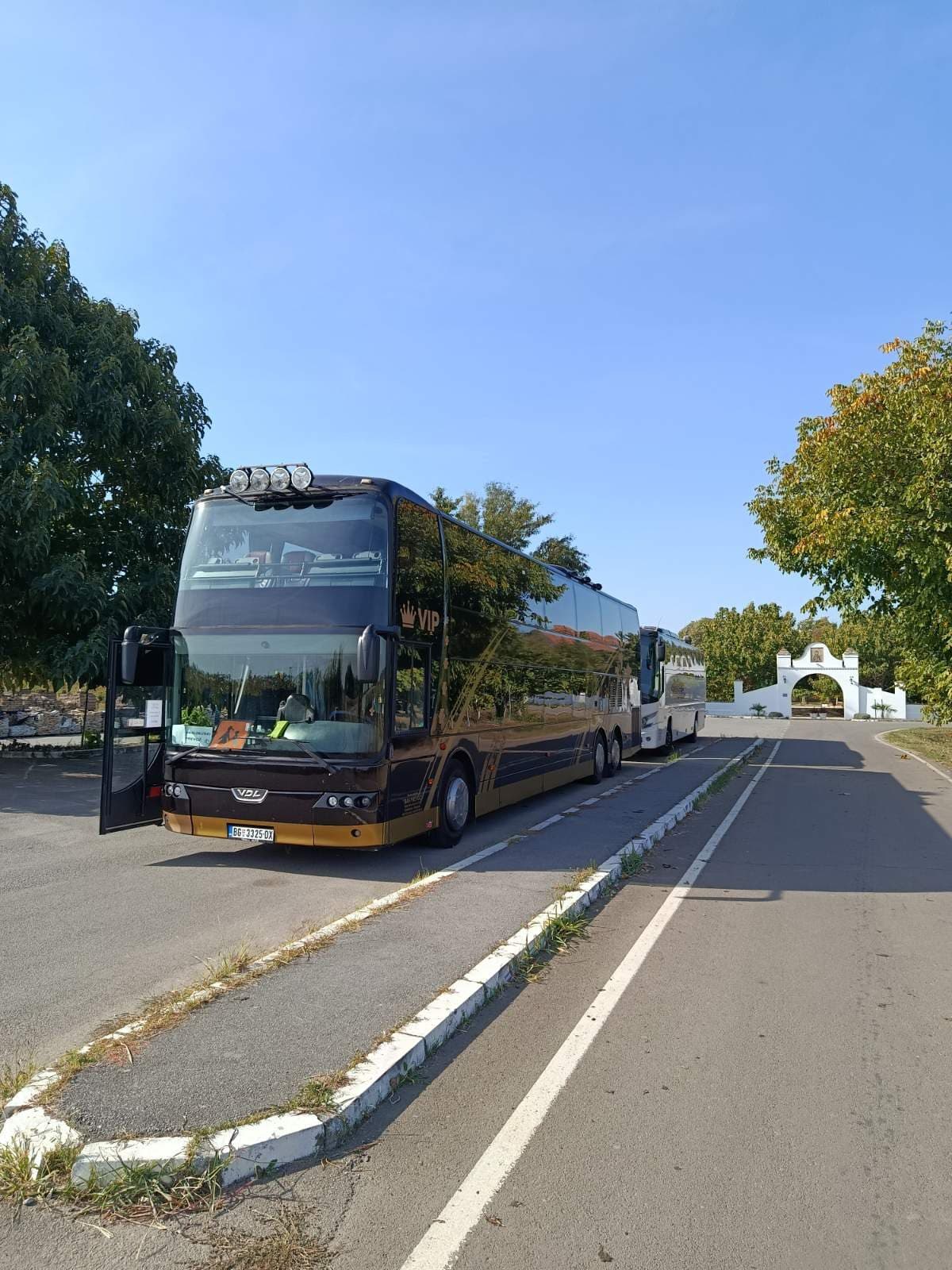 VDL Synergy VIP and a white coach in front of a monastery gate