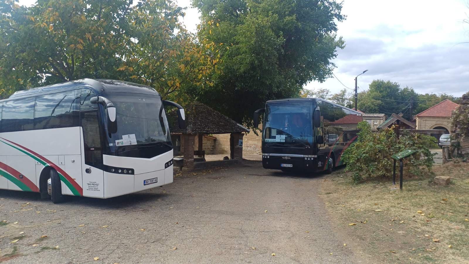 White and black BAS PREVOZ coaches in a village