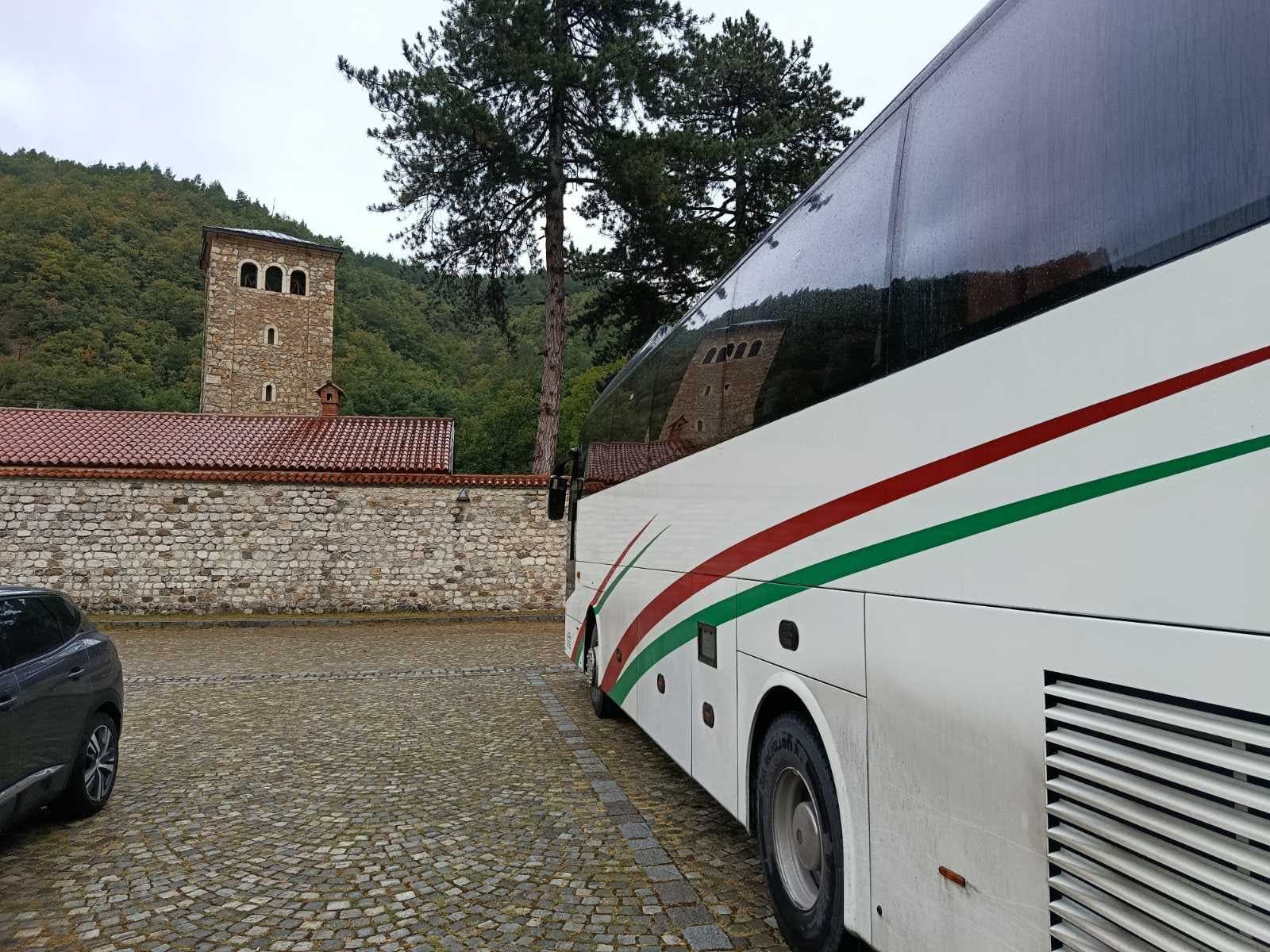 White coach beside a monastery stone wall